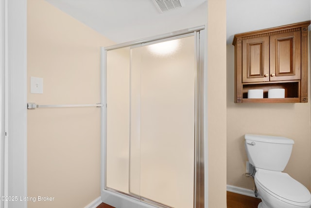 bathroom with toilet and a shower with door