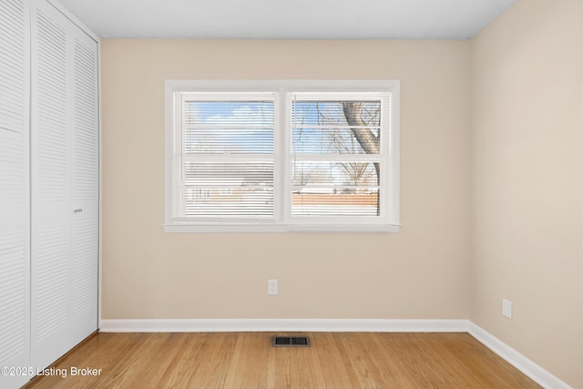 unfurnished bedroom featuring wood-type flooring and a closet