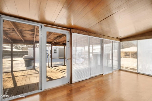 unfurnished sunroom with plenty of natural light, lofted ceiling, and wood ceiling