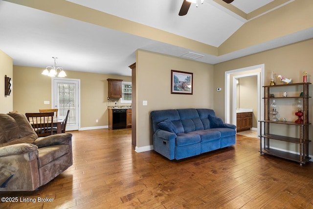 living room with dark hardwood / wood-style flooring, ceiling fan with notable chandelier, and vaulted ceiling