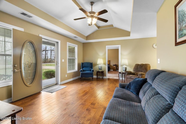 living room with a tray ceiling, ceiling fan, lofted ceiling, and hardwood / wood-style flooring