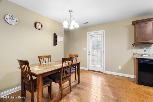 dining space featuring a notable chandelier and light wood-type flooring