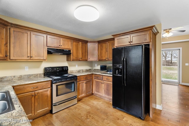 kitchen featuring black fridge, sink, stainless steel electric range oven, and light hardwood / wood-style floors