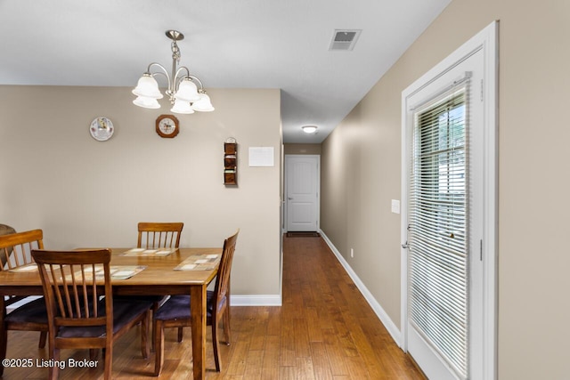 dining space featuring hardwood / wood-style floors and a notable chandelier