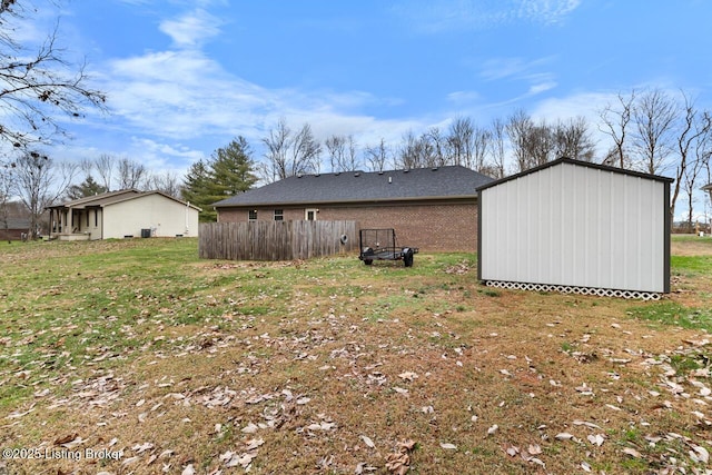 rear view of house with a yard and a storage unit