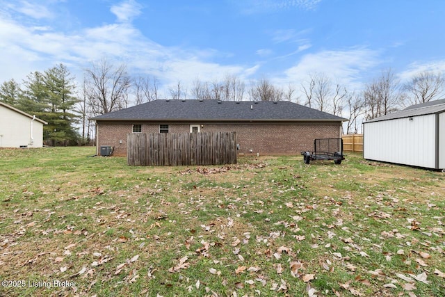 rear view of property with a yard and a storage shed