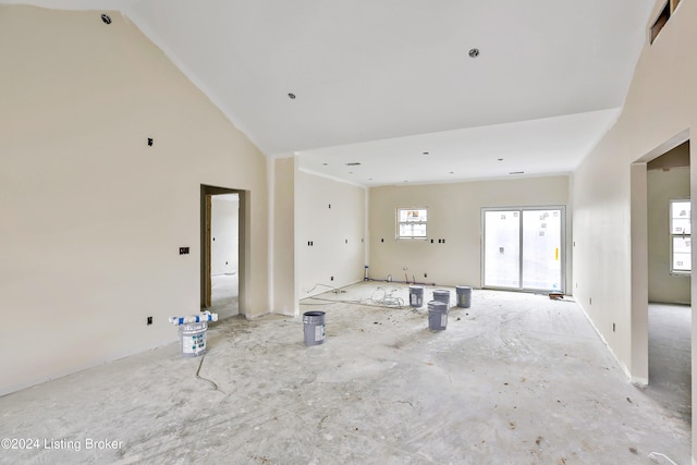 unfurnished living room with high vaulted ceiling