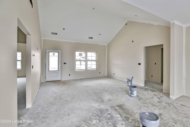 unfurnished living room with high vaulted ceiling