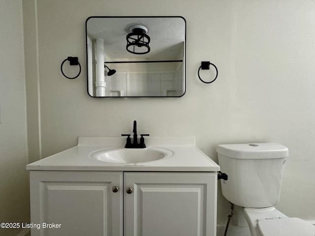 bathroom featuring vanity, toilet, and a textured ceiling