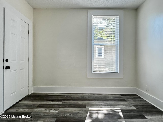 unfurnished room with dark hardwood / wood-style floors and a textured ceiling