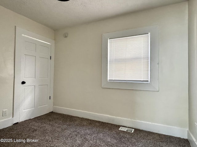 carpeted spare room featuring a textured ceiling