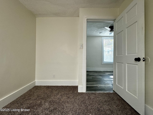 carpeted empty room with ceiling fan and a textured ceiling