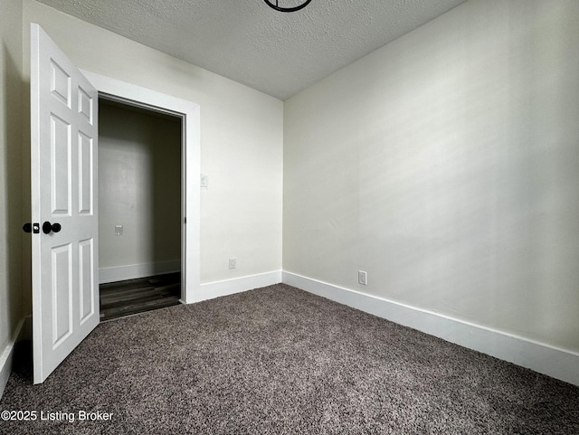 unfurnished bedroom with a textured ceiling and dark colored carpet