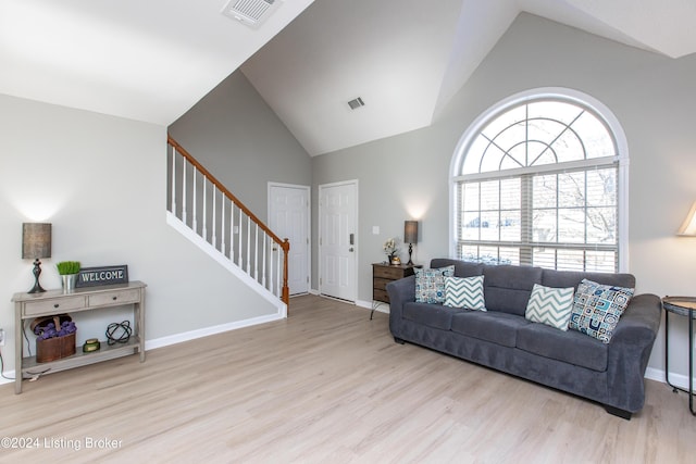 living room with light hardwood / wood-style floors and vaulted ceiling