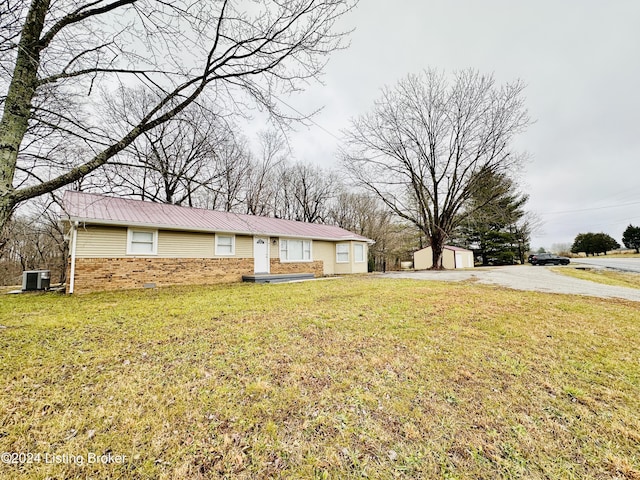 view of front of property featuring central AC unit, an outdoor structure, and a front lawn