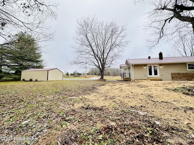 view of yard featuring an outbuilding and french doors