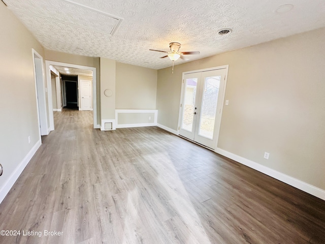 spare room with ceiling fan, french doors, a textured ceiling, and light wood-type flooring