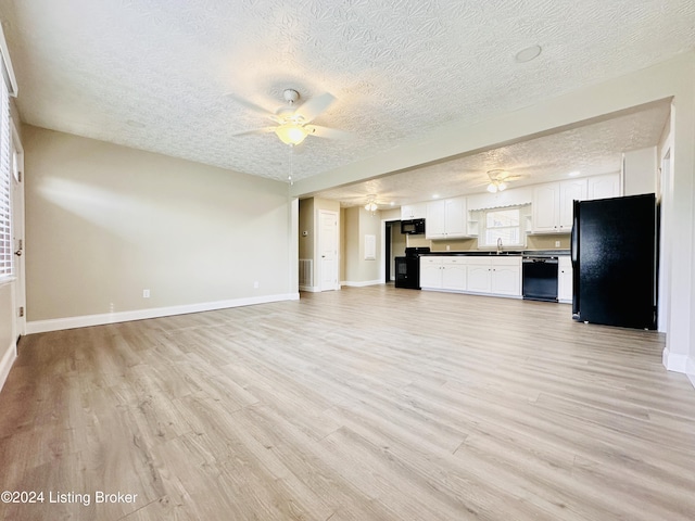 unfurnished living room with a textured ceiling, light hardwood / wood-style flooring, ceiling fan, and sink