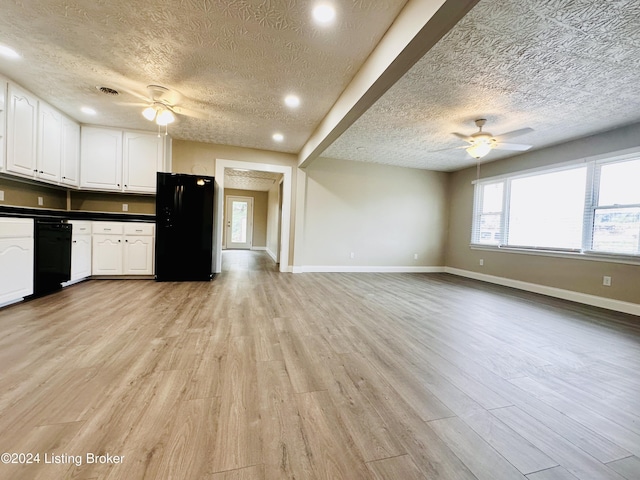 kitchen featuring white cabinets, a textured ceiling, light hardwood / wood-style flooring, and black appliances