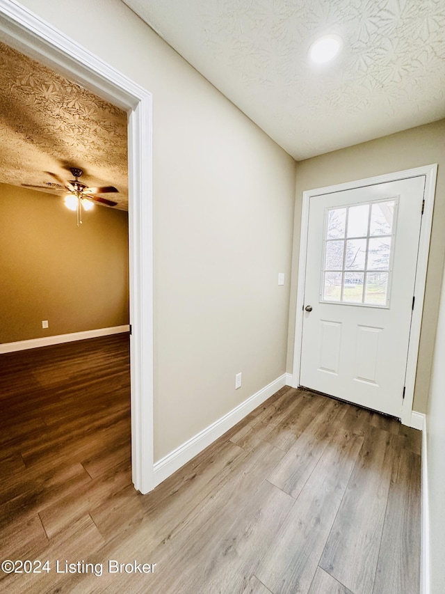 doorway featuring a textured ceiling and hardwood / wood-style flooring