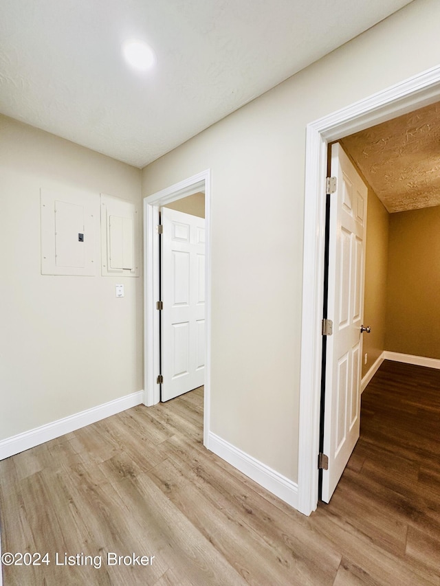 corridor featuring hardwood / wood-style floors and electric panel