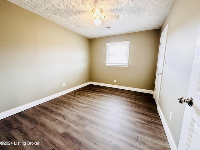 empty room with a textured ceiling and hardwood / wood-style flooring