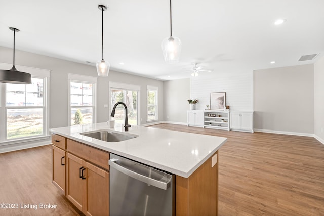 kitchen with ceiling fan, dishwasher, sink, decorative light fixtures, and a kitchen island with sink