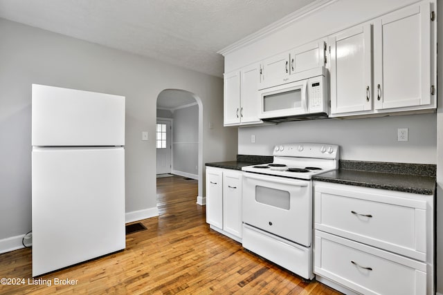 kitchen with white cabinets, light hardwood / wood-style floors, and white appliances