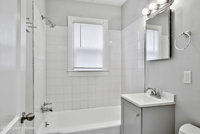 full bathroom with vanity, toilet, and tiled shower / bath