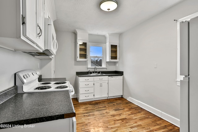 kitchen with sink, wood-type flooring, a textured ceiling, white appliances, and white cabinets