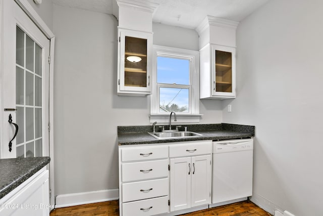 kitchen with white dishwasher, white cabinetry, dark hardwood / wood-style floors, and sink