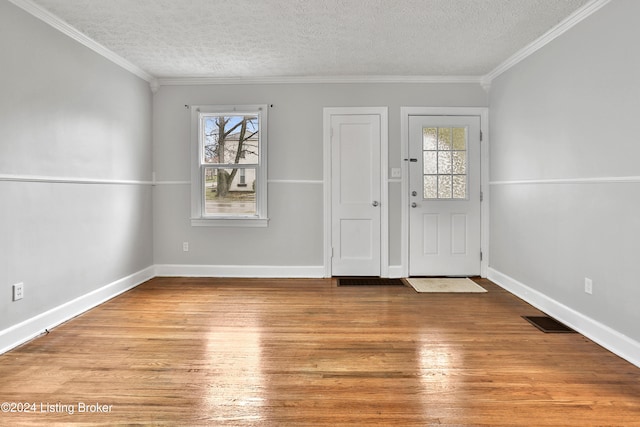 foyer entrance with a healthy amount of sunlight, light wood-type flooring, and ornamental molding