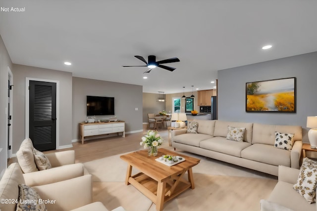 living room with ceiling fan and light hardwood / wood-style flooring