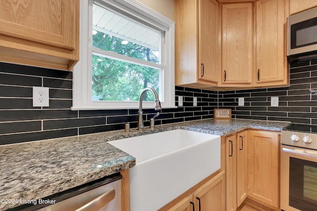 kitchen with sink, plenty of natural light, light brown cabinets, and appliances with stainless steel finishes