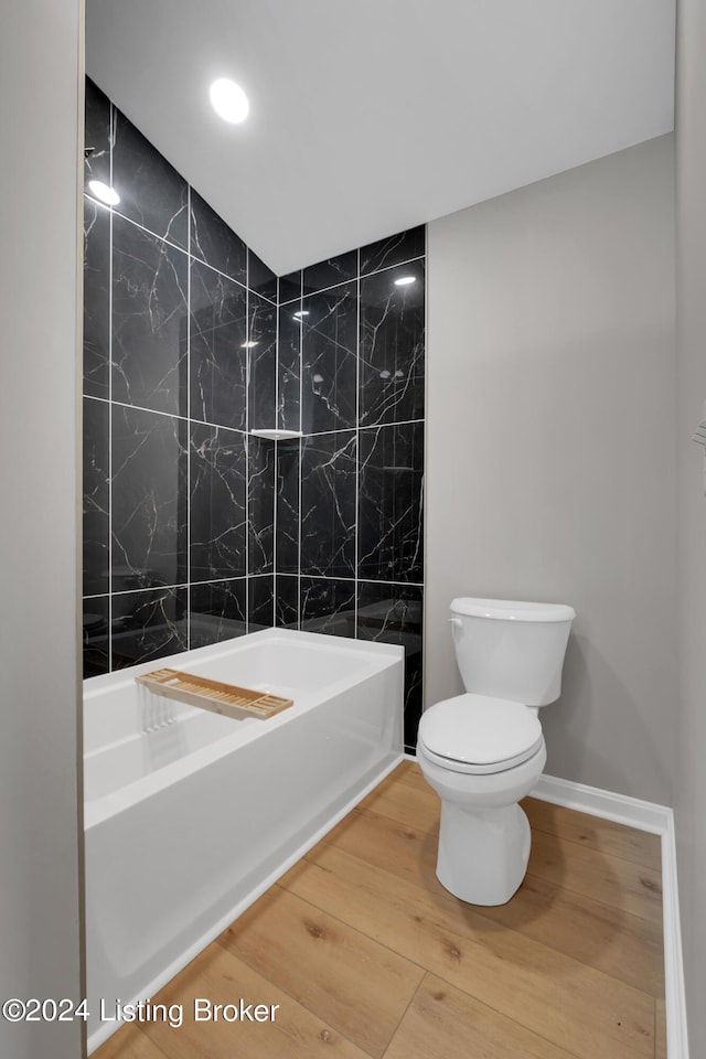 bathroom featuring hardwood / wood-style flooring, shower / tub combination, and toilet