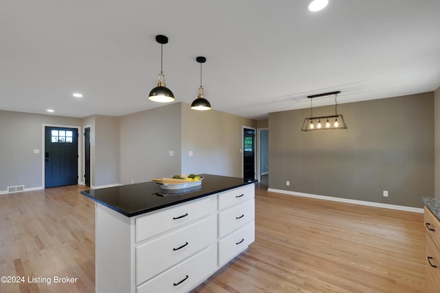 kitchen featuring a center island, light hardwood / wood-style floors, hanging light fixtures, and white cabinets