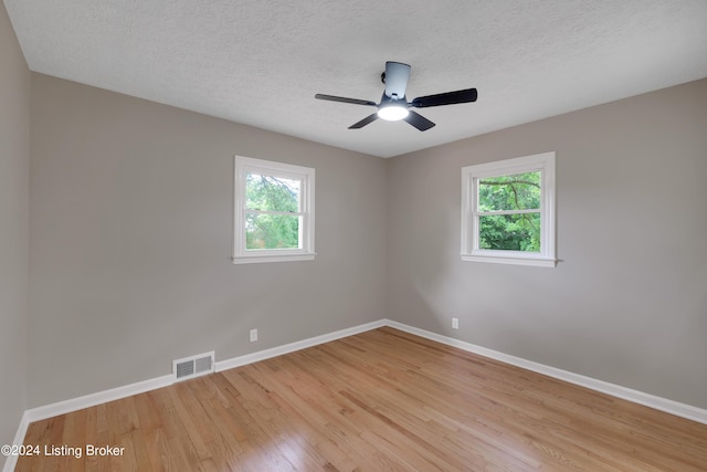 unfurnished room with ceiling fan, light hardwood / wood-style floors, and a textured ceiling