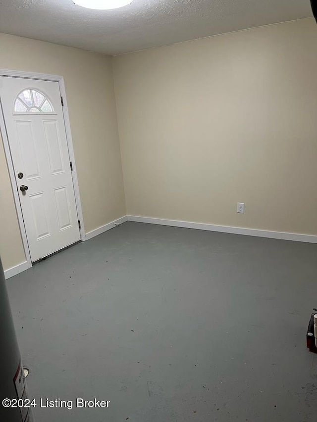 foyer featuring concrete flooring and a textured ceiling