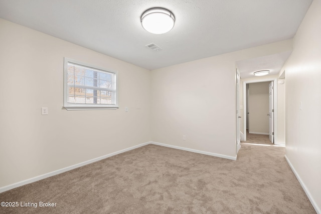 carpeted spare room with baseboards and visible vents