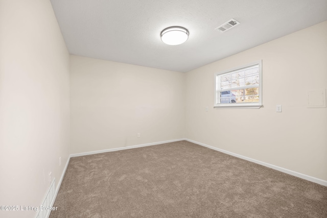 spare room featuring visible vents, baseboards, and carpet floors