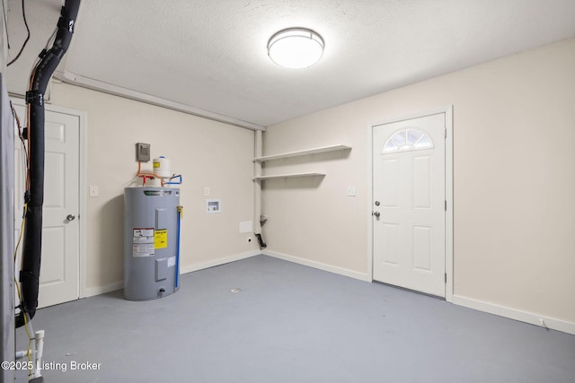 laundry area featuring a textured ceiling, water heater, baseboards, hookup for a washing machine, and laundry area