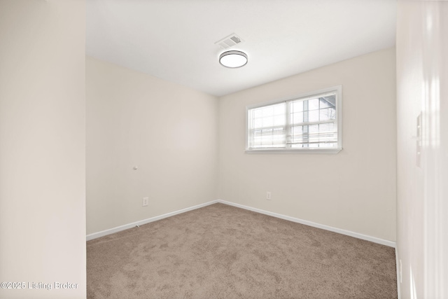 carpeted empty room with visible vents and baseboards