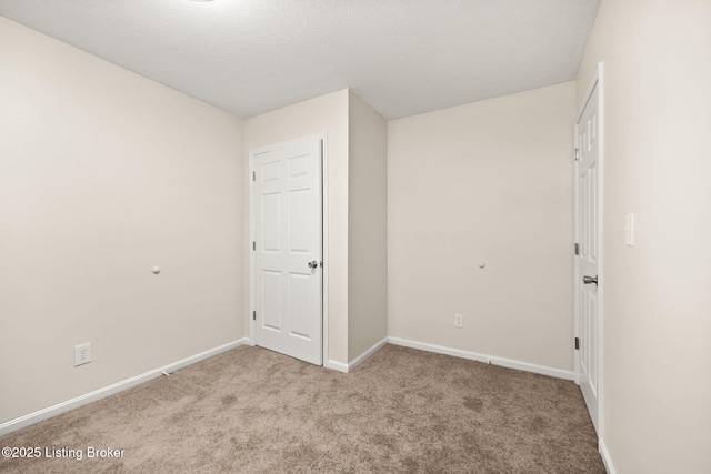 unfurnished bedroom with a textured ceiling, baseboards, and carpet floors