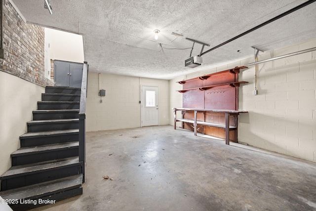 garage featuring concrete block wall and a garage door opener