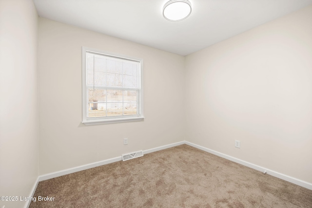 carpeted empty room with visible vents and baseboards