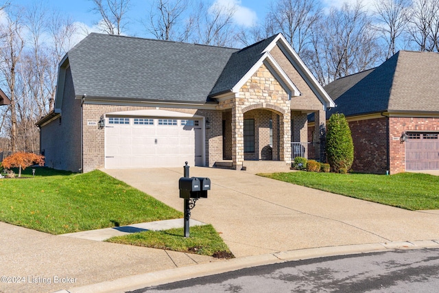 view of front of home featuring a porch, a front lawn, and a garage