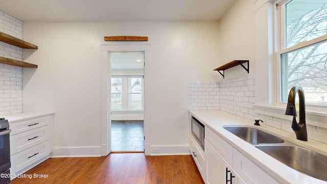 kitchen featuring backsplash, white cabinetry, and sink