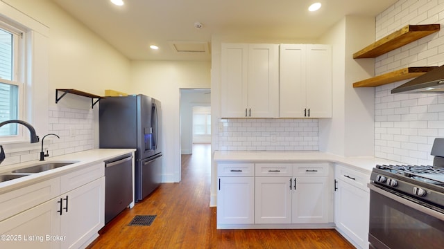 kitchen featuring appliances with stainless steel finishes, tasteful backsplash, white cabinetry, and sink