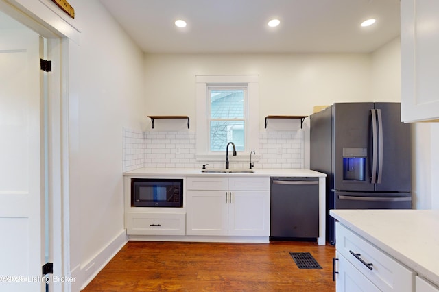 kitchen with white cabinets, sink, appliances with stainless steel finishes, and tasteful backsplash