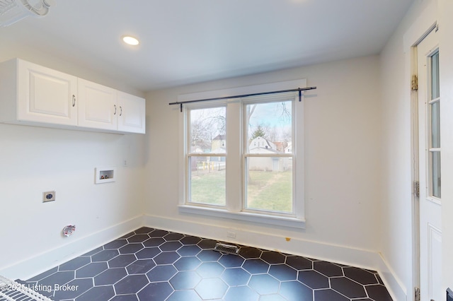 laundry room with electric dryer hookup, hookup for a washing machine, and cabinets